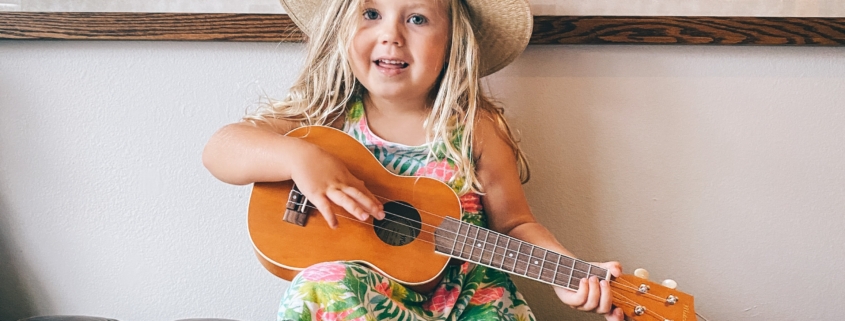 A preschooler with a cowboy hat and guitar