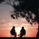 Silhouettes sitting in front of a sunset