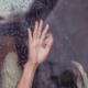A grieving woman behind a window