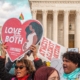 Pro-life people hold signs outside the Supreme Court. One sign says "Love them Both" and another says "Atheist Against Abortion."