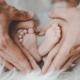 Adult hands cradle a baby's feet
