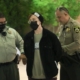 Herb Geraghty in handcuffs, accompanied by police officers