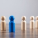 Blue Wooden Figure Standing Out From Crowd